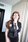 Pigtailed redhead in police uniform takes her bra off