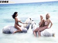 Three charming bosomy babes pose on the beach all naked