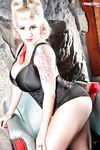 Buxom blonde retro model September Carrino posing in black corset and heels
