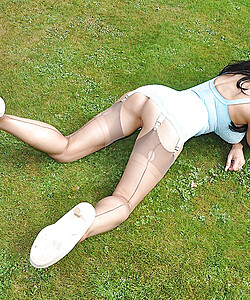 Busty MILF Lou Jenson shows off her nylon clad legs in heels on the lawn